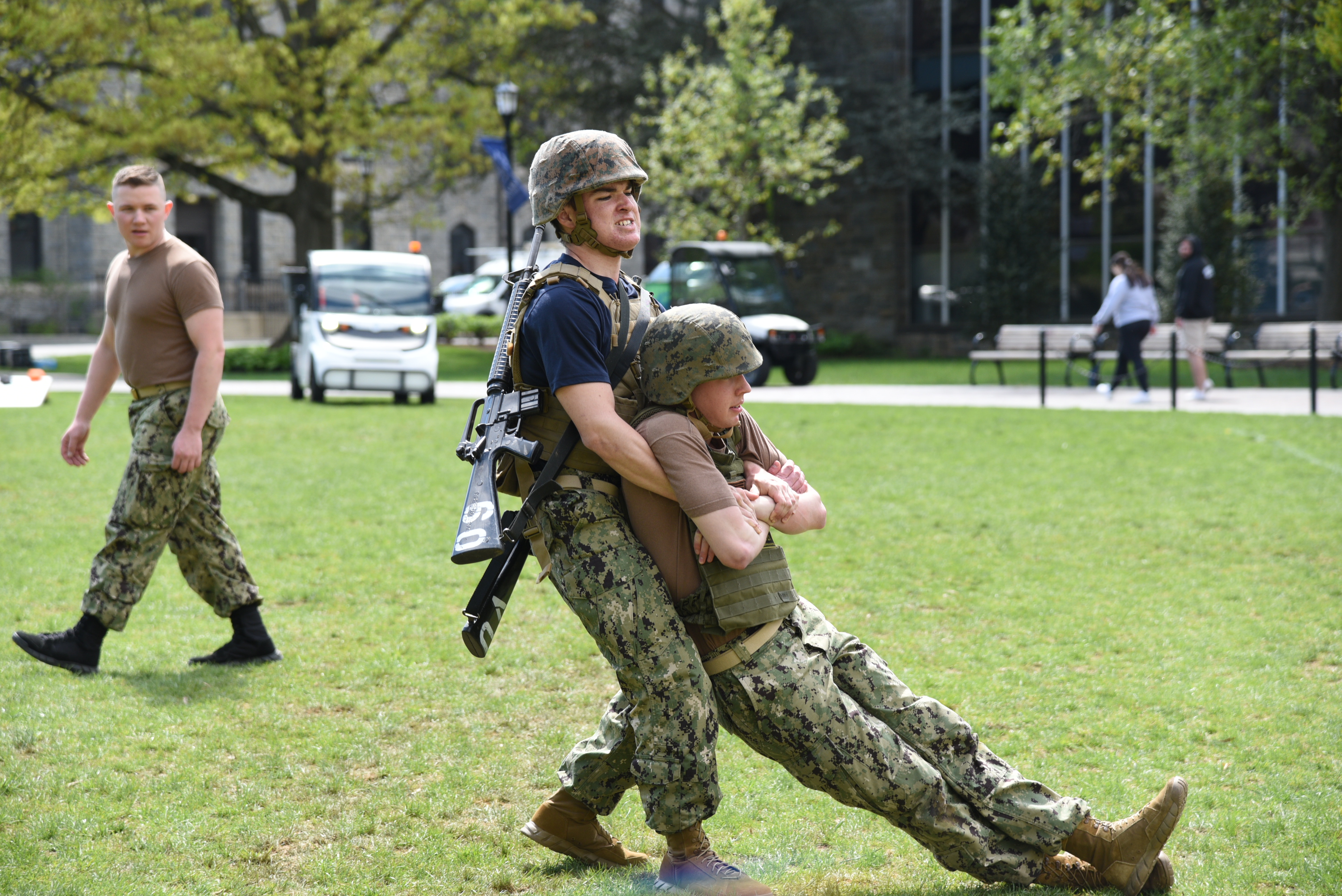 two people in military uniforms, one dragging the other