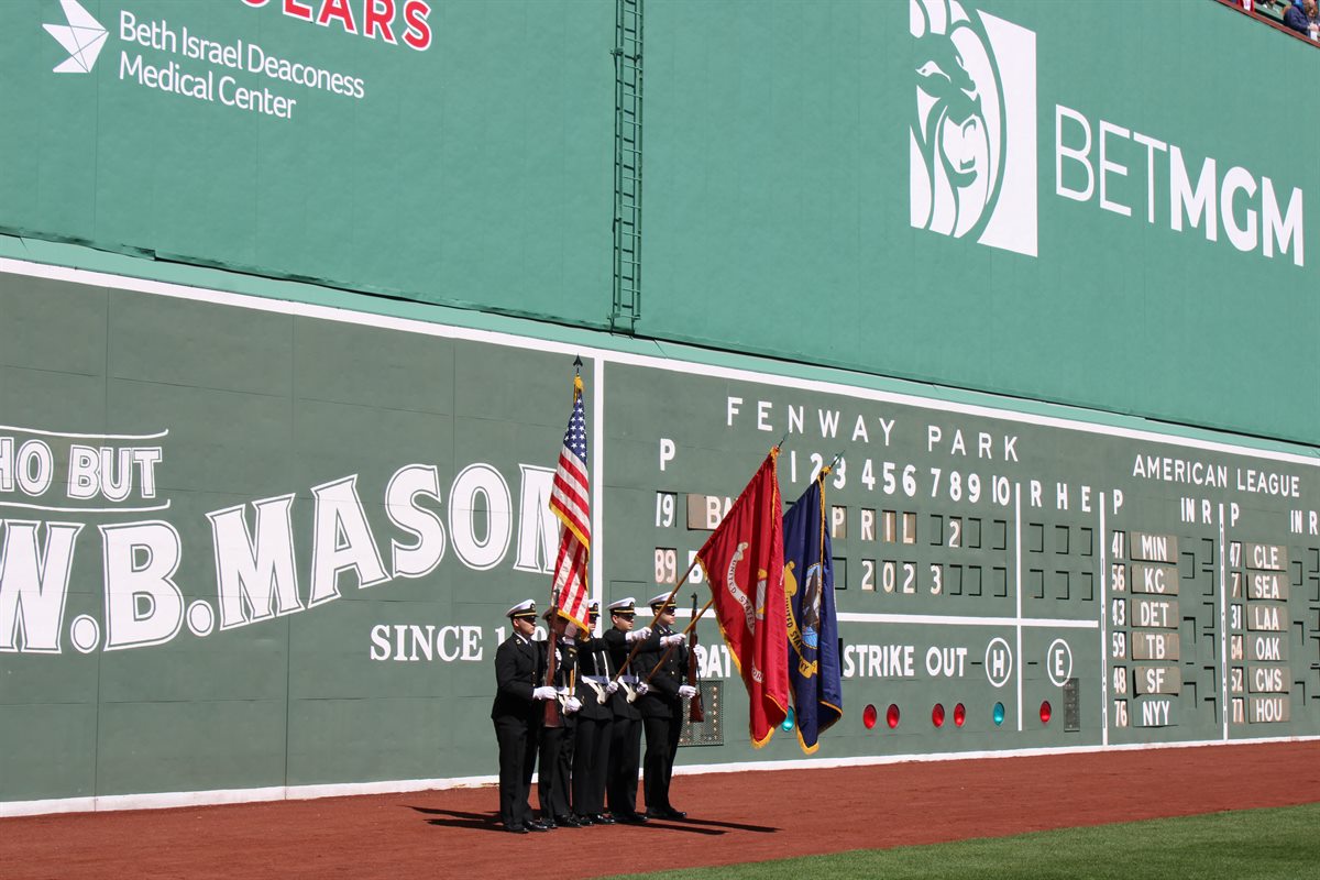 People in military uniforms holding flags